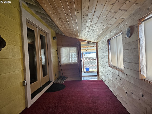 hall with wood walls, lofted ceiling, and wood ceiling