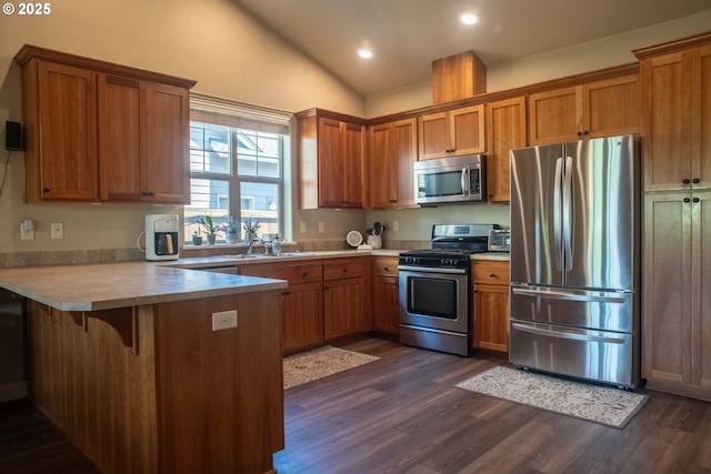1008 S 41st St, Springfield, OR 97478 - kitchen with appliances with stainless steel finishes, a peninsula, brown cabinetry, dark wood-style flooring, and recessed lighting