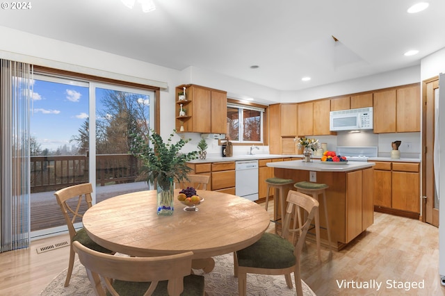 kitchen featuring white appliances, a center island, and light hardwood / wood-style flooring