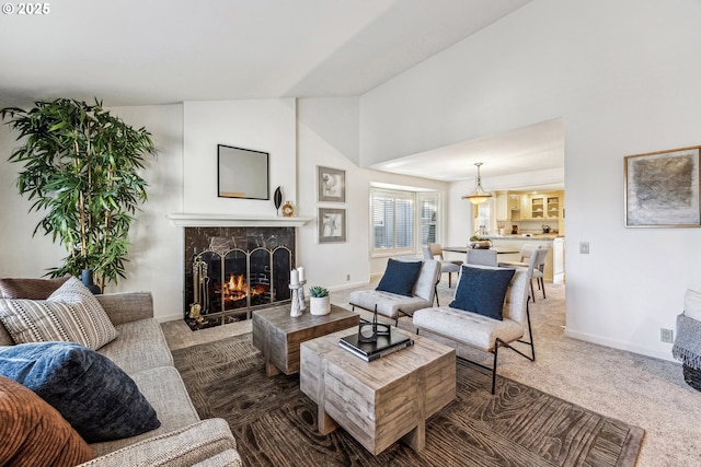 living room with dark colored carpet, high vaulted ceiling, and a high end fireplace