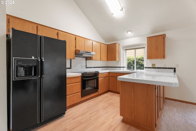 kitchen with black appliances, backsplash, vaulted ceiling, kitchen peninsula, and light hardwood / wood-style flooring