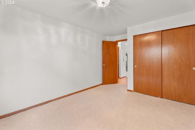 unfurnished bedroom featuring a textured ceiling and a closet