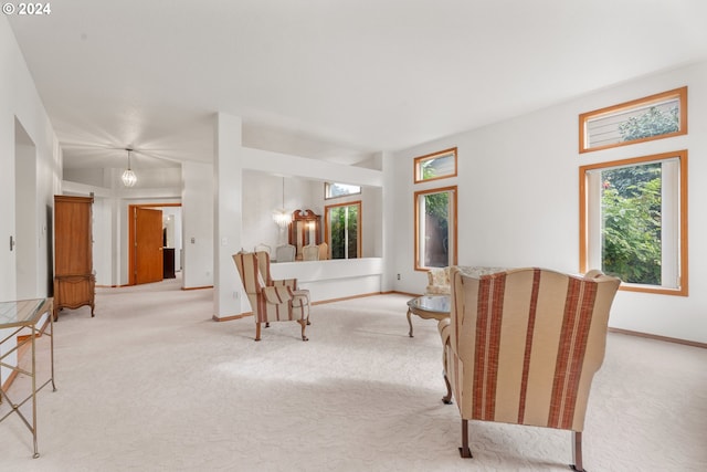 living room featuring an inviting chandelier and light colored carpet