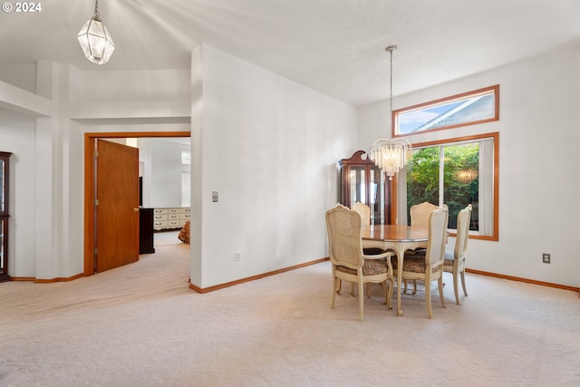 carpeted dining room featuring vaulted ceiling and an inviting chandelier