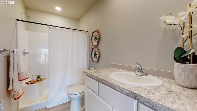 bathroom with toilet, hardwood / wood-style floors, and vanity