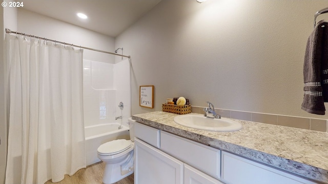 full bathroom featuring vanity, hardwood / wood-style floors, toilet, and shower / bathtub combination with curtain