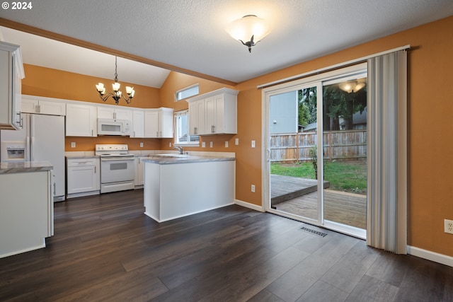 kitchen with dark hardwood / wood-style flooring, white appliances, vaulted ceiling, white cabinets, and hanging light fixtures