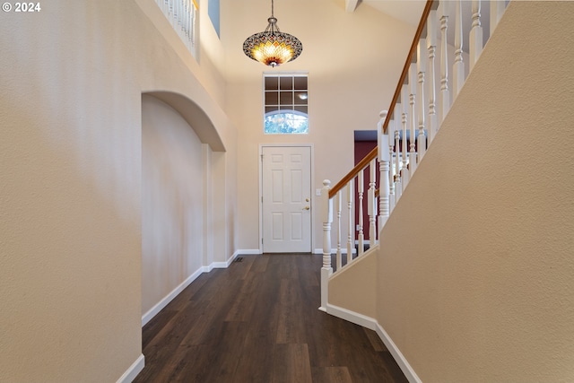 foyer entrance with dark hardwood / wood-style flooring and high vaulted ceiling