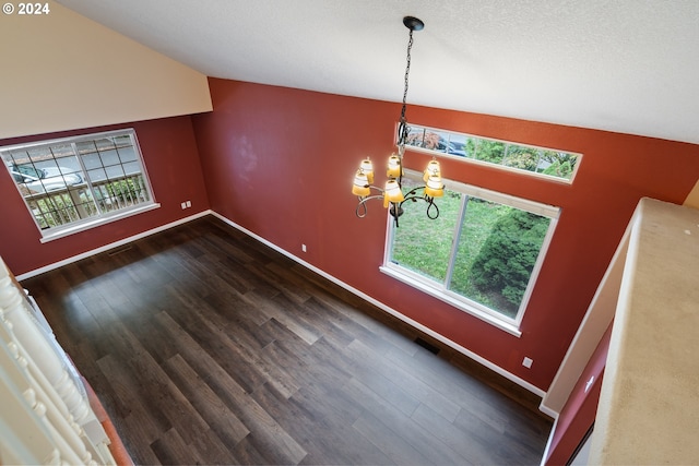 unfurnished dining area featuring dark hardwood / wood-style floors, vaulted ceiling, and a healthy amount of sunlight