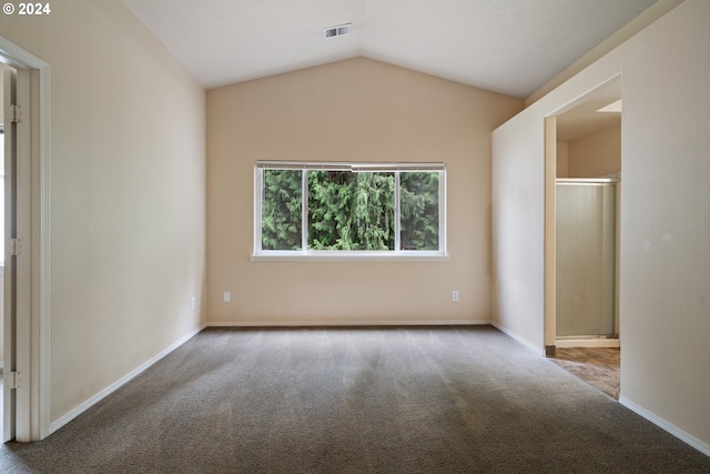 unfurnished bedroom with carpet flooring and lofted ceiling