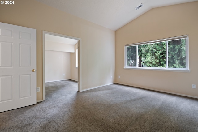 carpeted spare room featuring vaulted ceiling