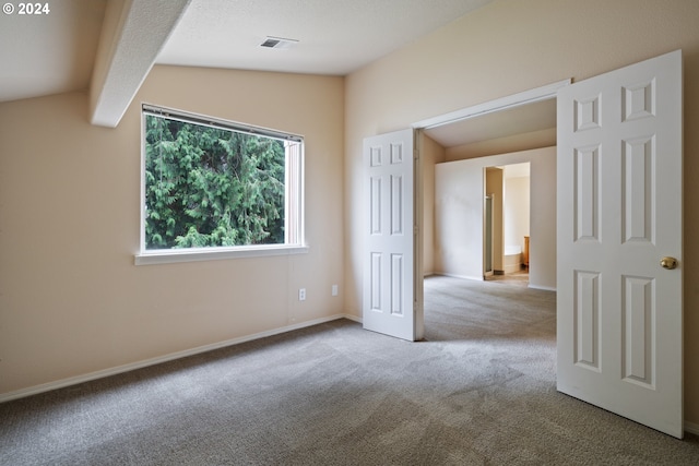 carpeted empty room with vaulted ceiling with beams