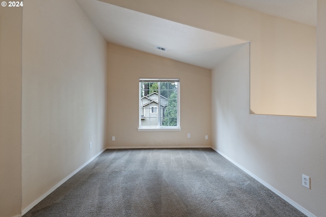 unfurnished room with carpet and vaulted ceiling