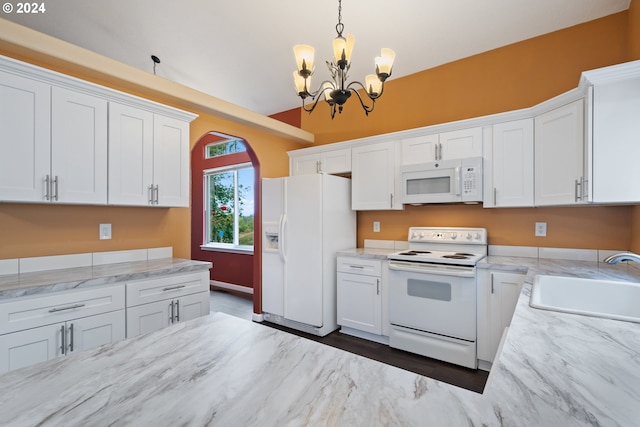 kitchen with white cabinetry, sink, decorative light fixtures, and white appliances