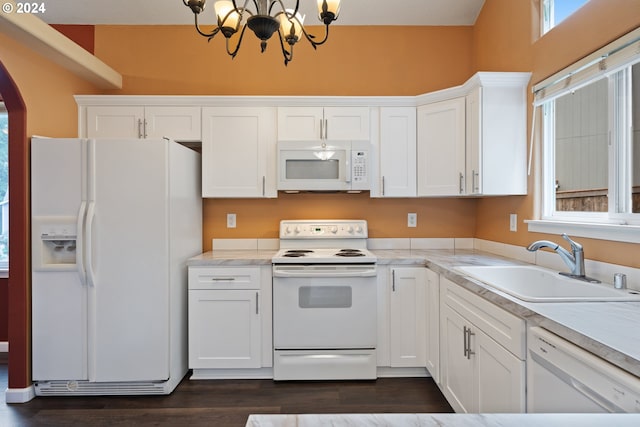 kitchen with white appliances, dark wood-type flooring, white cabinets, sink, and a chandelier