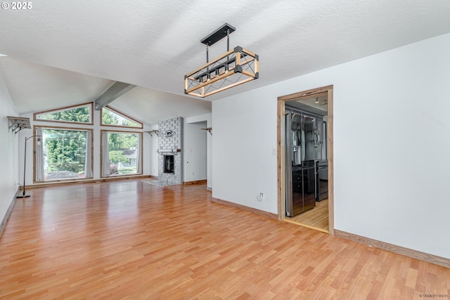 1504 SW 24th St, Troutdale, OR 97060 - unfurnished living room featuring light wood finished floors, baseboards, a fireplace, vaulted ceiling, and a textured ceiling