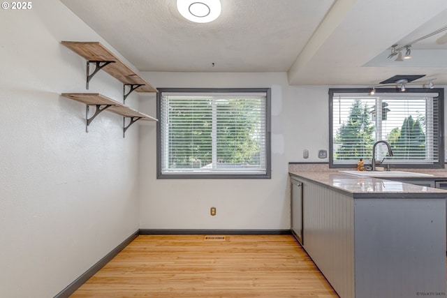1504 SW 24th St, Troutdale, OR 97060 - kitchen with a sink, light wood-style floors, open shelves, baseboards, and track lighting