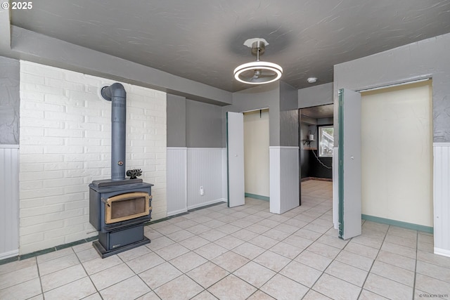 1504 SW 24th St, Troutdale, OR 97060 - unfurnished living room featuring wainscoting, a wood stove, and light tile patterned flooring