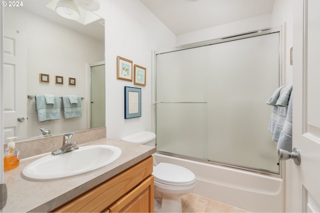 full bathroom with vanity, bath / shower combo with glass door, tile patterned floors, and toilet