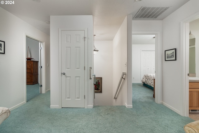 hallway featuring light colored carpet