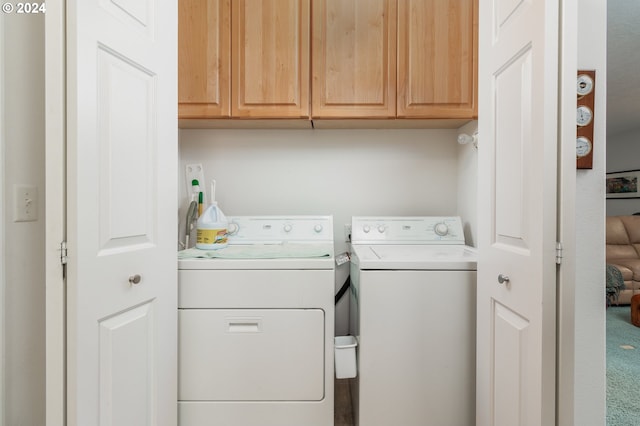 washroom with separate washer and dryer and cabinets