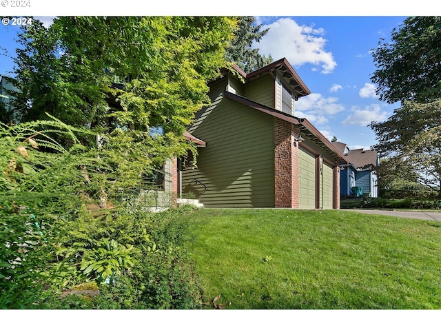 view of side of home featuring a lawn and a garage