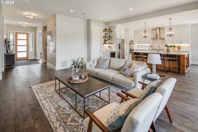 living room with sink, a chandelier, and dark hardwood / wood-style flooring