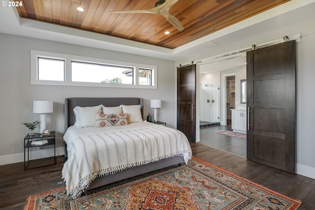 bedroom featuring a barn door, wood ceiling, and a tray ceiling