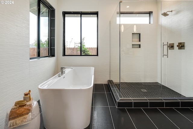 bathroom with tile walls, tile patterned floors, and separate shower and tub