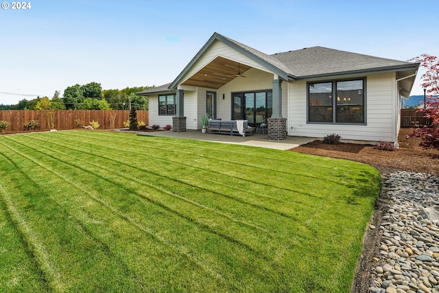 back of property with an outdoor hangout area, a patio area, and a lawn