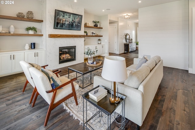 living room with a fireplace, built in features, and dark hardwood / wood-style floors