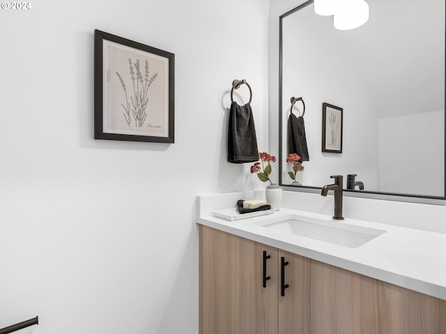 bathroom with vanity and lofted ceiling