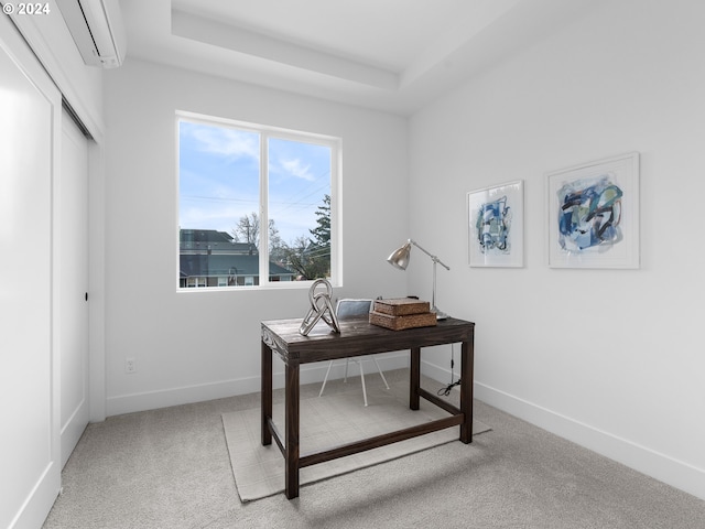 office space featuring light colored carpet, a wall mounted AC, and a tray ceiling