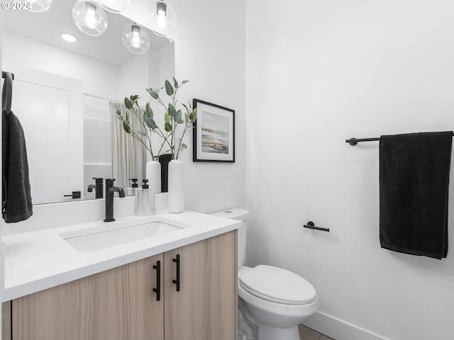 bathroom with tile patterned flooring, vanity, and toilet