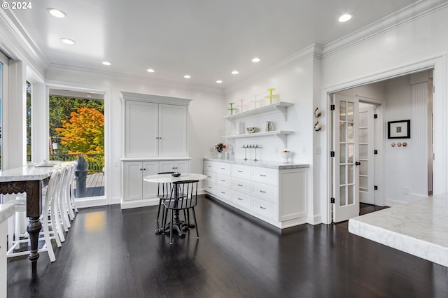 kitchen with dark hardwood / wood-style flooring, french doors, light stone counters, white cabinetry, and crown molding