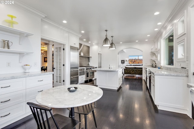 kitchen with white cabinetry, dark hardwood / wood-style floors, a center island, and light stone countertops