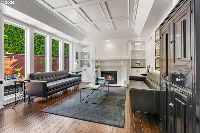 living room featuring coffered ceiling, dark hardwood / wood-style flooring, and built in features