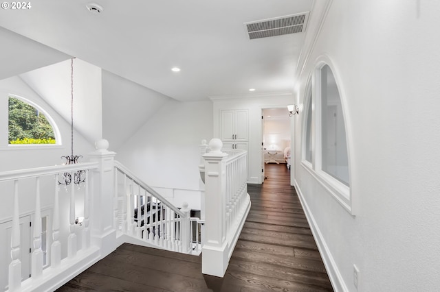 hallway featuring ornamental molding, dark hardwood / wood-style flooring, and lofted ceiling