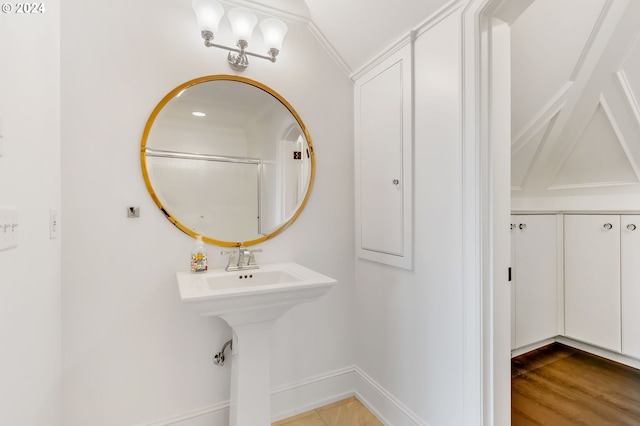 bathroom with vaulted ceiling, hardwood / wood-style floors, and crown molding