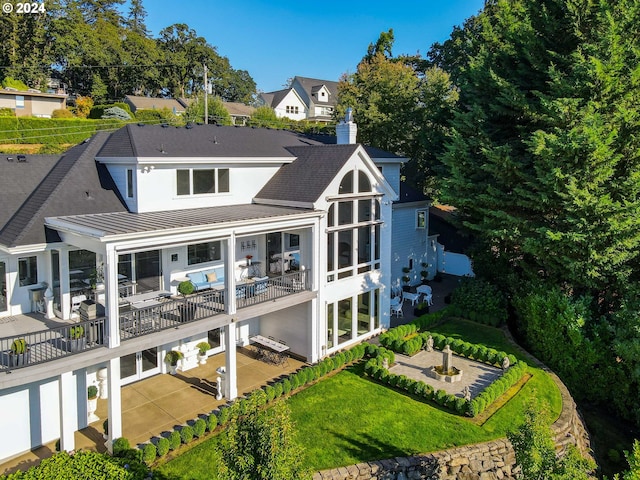 back of house featuring a lawn and a patio area