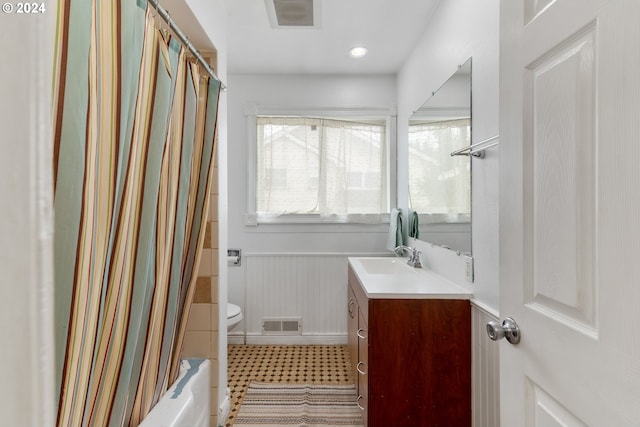 full bathroom with vanity, shower / bath combo, and toilet