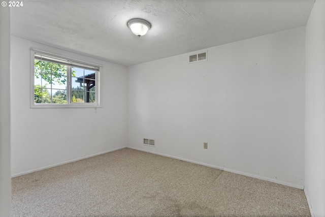 unfurnished room featuring carpet flooring and a textured ceiling