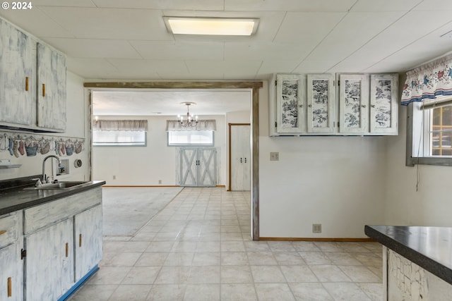 kitchen with sink, plenty of natural light, decorative light fixtures, and light tile floors