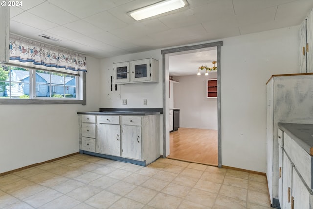 kitchen featuring light tile flooring and white cabinetry