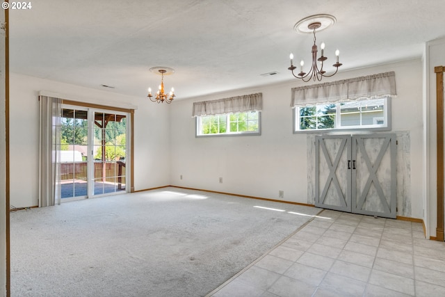 empty room with a wealth of natural light, a notable chandelier, and light tile flooring