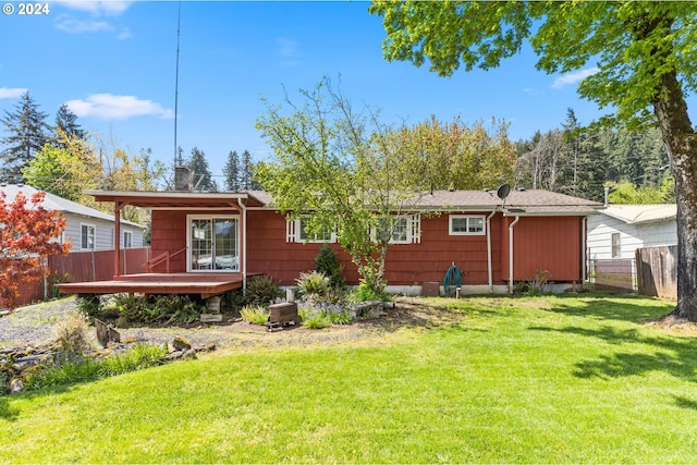 back of house with a wooden deck and a lawn