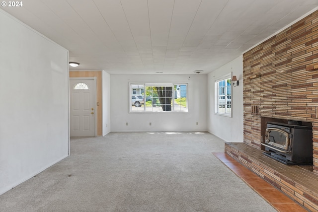 unfurnished living room featuring carpet, a wood stove, and a fireplace