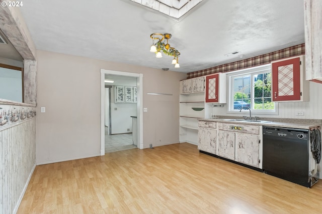 kitchen with a skylight, sink, light wood-type flooring, and black dishwasher