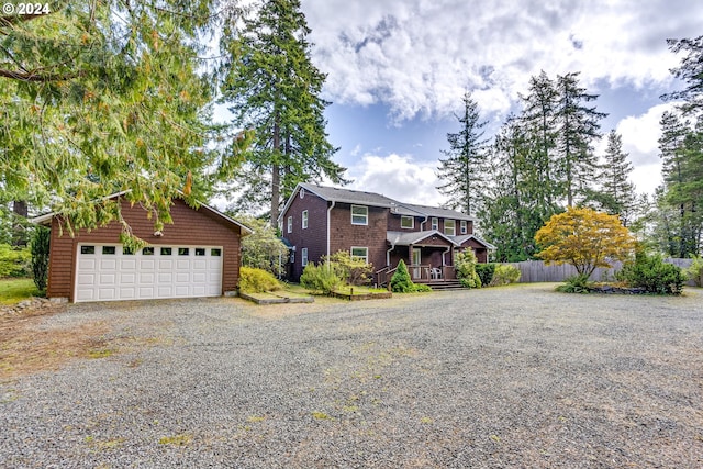 view of front of home with a garage, an outdoor structure, and gravel driveway
