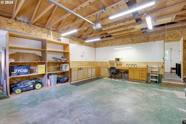 garage with a garage door opener and a workshop area